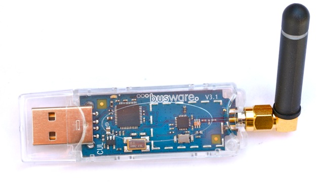 USB enabled CC1101 controller board with RP-SMA socket and lambda/4 antenna in transparent plastic case. Optional HF-shield not mounted.