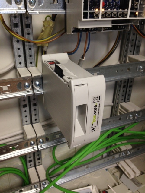 DIN-rail device installed in a distribution board, wired to KNX and network